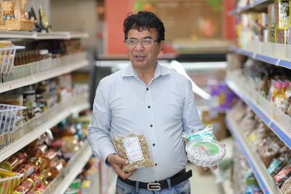 Kabul Market owner Basser Basil holds some products from Afghanistan. Basil said it’s common for customers to come from across Georgia and even as far away as Florida and Texas to shop in his store.
 Wednesday, November 17, 2021. Miguel Martinez for The Atlanta Journal-Constitution 