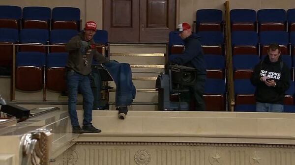 Bruno Cua (left) stands on the balcony of the Senate gallery on Jan. 6, 2021. Cua was convicted of two felonies relating to his actions during the U.S. Capitol riot.