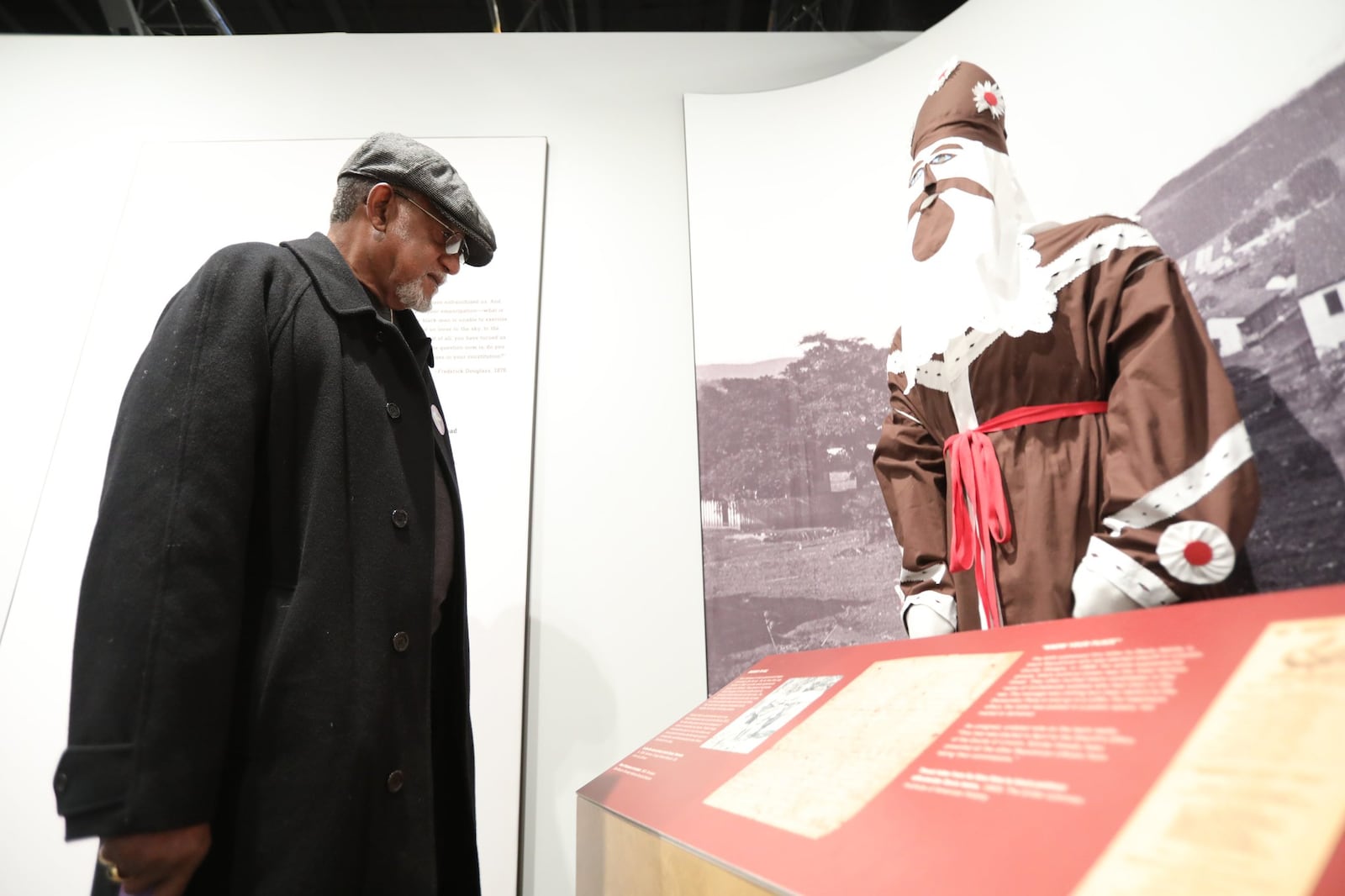 Charly Brown from Colorado examines a replica of an early Ku Klux Klan robe on display in the “Black Citizenship in the Age of Jim Crow” at the Atlanta History Center. CONTRIBUTED BY Miguel Martinez