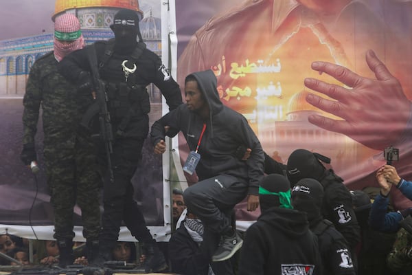 Israeli hostage Avera Mengisto is escorted by Hamas fighters before being handed over to the Red Cross in Rafah, southern Gaza Strip, on Saturday, Feb. 22, 2025. (AP Photo/Jehad Alshrafi)