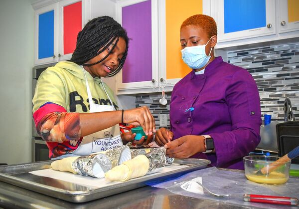 Sydney Sims, 12, of Atlanta adds the final touches of sugar sprinkles to her cream horn pastry just prior to baking while Young Chefs Academy instructor Christina Glass looks on. CONTRIBUTED BY CHRIS HUNT PHOTOGRAPHY