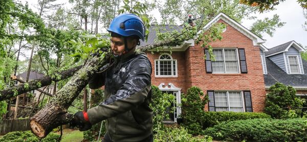 May 3, 2021 Atlanta: Brandon Mazarie of Castor Tree Service brings out sawed limbs as his crew removed a tree from a house on Forest Crossing Drive on Monday, May 3, 2021. A possible tornado tracked on the ground for several miles, starting in Douglas County and moved northeast through the city into northern DeKalb County, according to Channel 2 Action News meteorologists. The National Weather Service will conduct a survey to confirm the tornado and determine its strength. In Atlanta, fire crews responded to a number of calls for trees down on homes and on the streets along the Cascade Road corridor. (John Spink / John.Spink@ajc.com)

