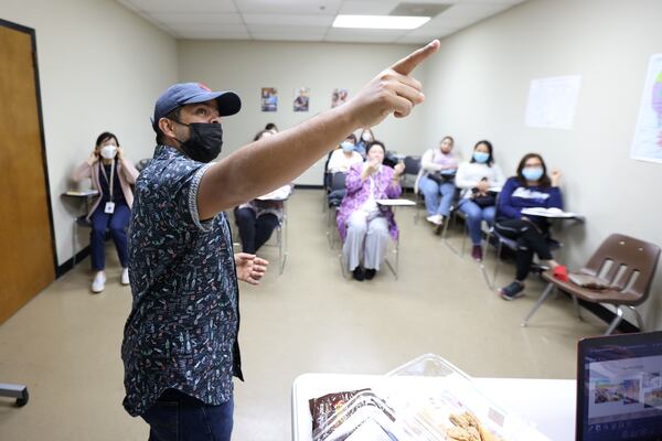 Second-level student Alejandro Murillo delivers a presentation about his home country of Colombia during his English class on Nov. 11, 2021. Most of the students studying through the Center for Pan Asian Community Services are immigrants who, despite the pandemic, continue to seek ways to improve their English. (Miguel Martinez for The Atlanta Journal-Constitution) 