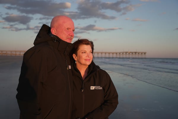 Susan and Greg Scarbro stand together for a portrait at sunset in Sunset Beach, N.C. on Jan. 3, 2025. (AP Photo/Laura Bargfeld)