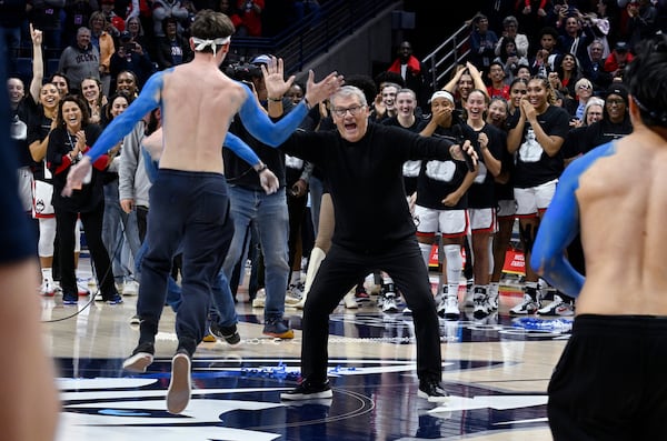 UConn head coach Geno Auriemma high fives students he called out onto the court during a post game ceremony celebrating the most wins in college basketball history, Wednesday, Nov. 20, 2024, in Storrs, Conn. (AP Photo/Jessica Hill)