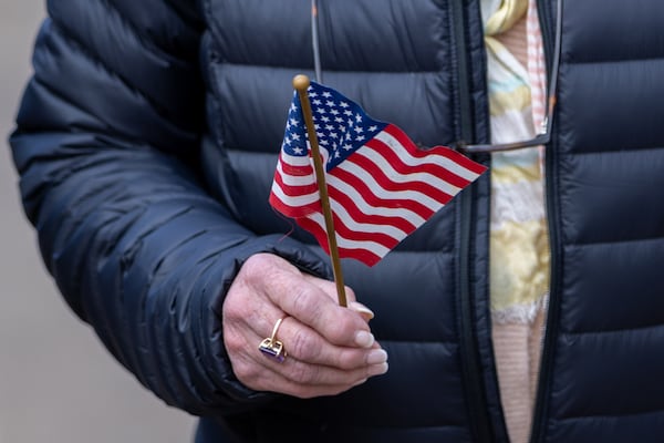 Joyce Norman holds a flag while walking to the Carter Center in Atlanta on Sunday, January 5, 2025. Former president Jimmy Carter, who died at 100, is lying in repose at the center. (Arvin Temkar / AJC)