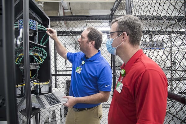 Floyd Medical Center network engineers Daniel Wilson (right) and Kevin Prewett (left) configure the network inside of a newly constructed pop-up hospital located in the parking garage at Floyd Medical Center in Rome,. (ALYSSA POINTER / ALYSSA.POINTER@AJC.COM)