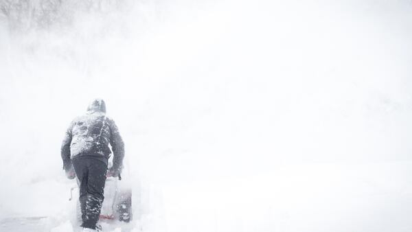 FILE PHOTO: A man uses his snowblower to clear his driveway and the road  following a major snow storm .