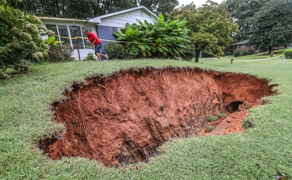 Anthony Schannell (pictured) says the sinkhole at his cousin’s home located on James Street in Marietta had grown bigger on Friday. (John Spink / John.Spink@ajc.com)

