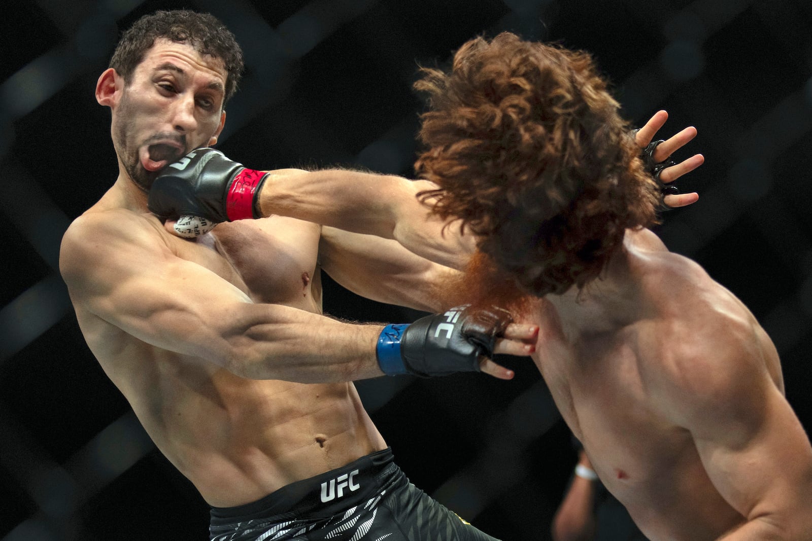 Shara Magomedov, right, punches Armen Petrosyan during a middleweight mixed martial arts bout at UFC Fight Night on Saturday, Oct. 26, 2024, in Abu Dhabi, United Arab Emirates. (AP Photo/Altaf Qadri)