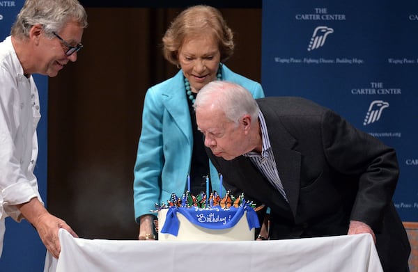 Former President Jimmy Carter blows out the candles on his cake for his 90th birthday celebration with staff and guests at the Day Chapel of the Ivan Allen III Pavilion at the Carter Center on Oct. 1, 2014 in Atlanta, Georgia. (Hyosub Shin/The Atlanta Journal-Constitution/TNS)