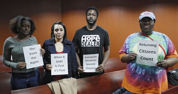 Community organizers for The New Georgia Project, a voting rights group, stood silently with signs after a Senate study commmittee voted against restoring felon voting rights.  After a brief discussion, the committee voted Wednesday to maintain the status quo.   Bob Andres / bandres@ajc.com