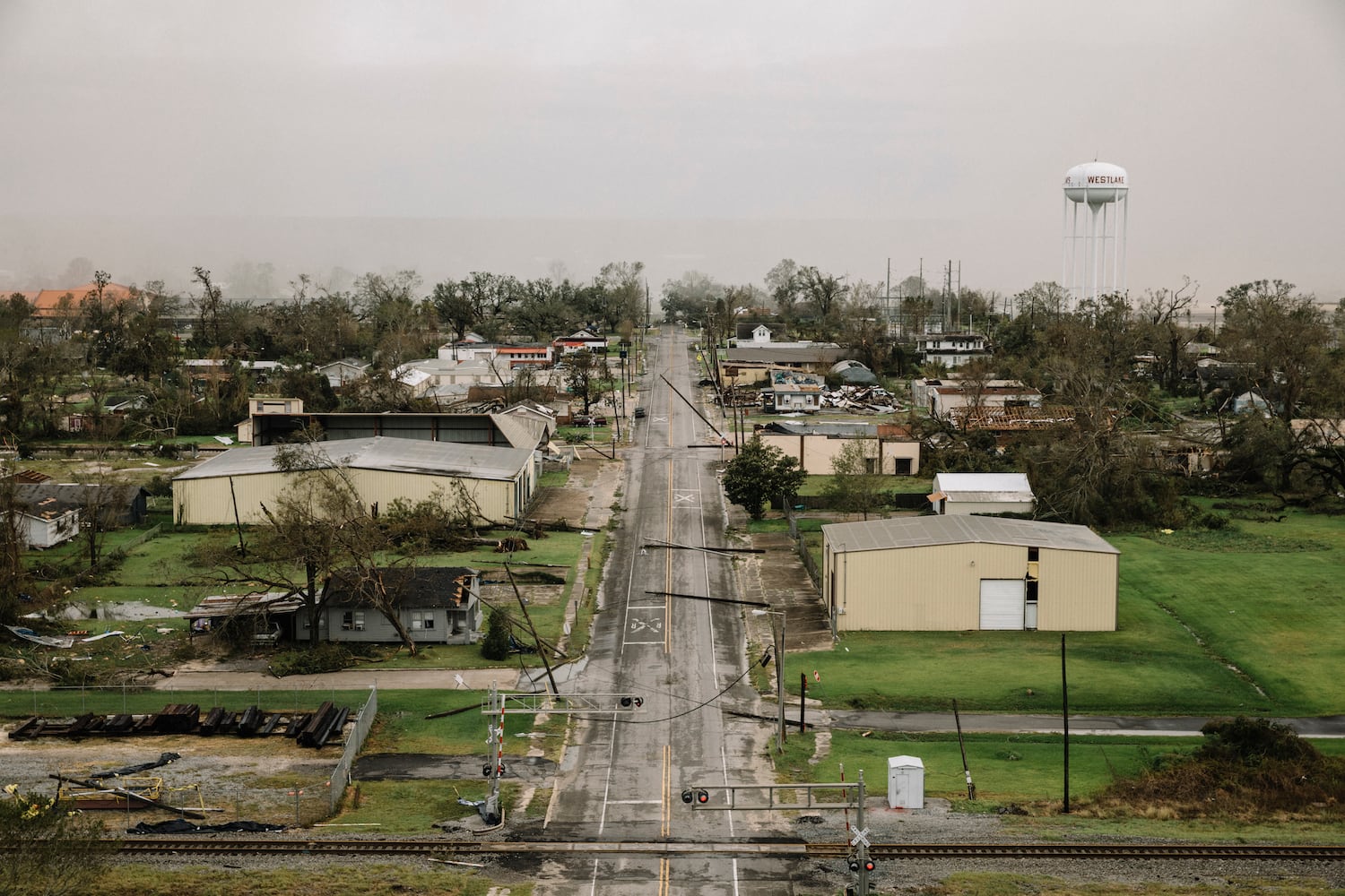 Smoke form an industrial plant fire hangs over Westlake, La., a small community across the river from Lake Charles, on Thursday, Aug. 27, 2020, where Hurricane Laura knocked down trees and power poles. (William Widmer/The New York Times)