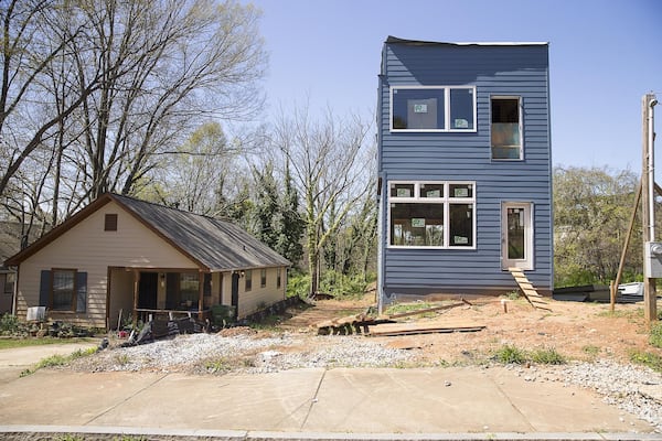 A newly developed house sits next to an older residence in the Summerhill community. 