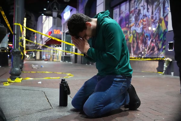 Matthias Hauswirth of New Orleans prays on the street near the scene where a vehicle drove into a crowd on New Orleans' Canal and Bourbon streets, Wednesday, Jan. 1, 2025. (AP Photo/George Walker IV)