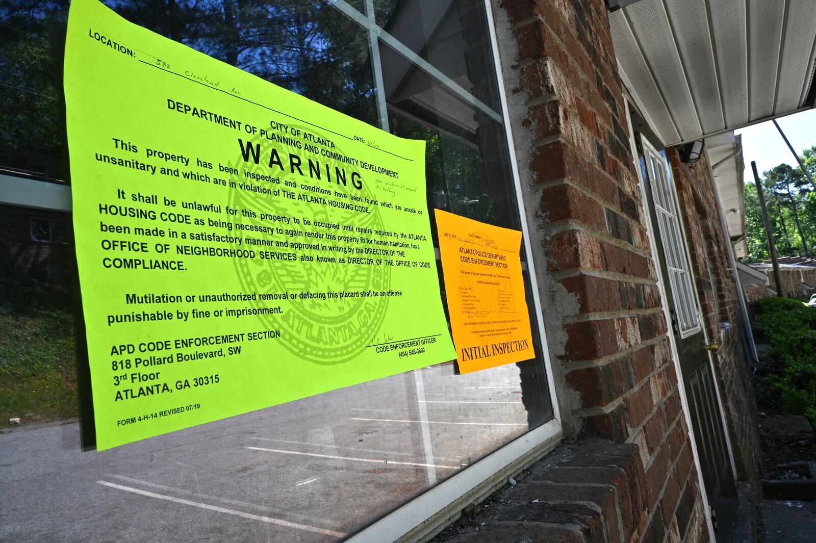 Code enforcement notices posted on building 15 of Pavilion Place warn that it is unfit for habitation. A fire destroyed several apartments there on Sept. 23, but the notices were not posted until May. Tenants continued to live there because they could not afford moving costs, and managers allowed a new family to rent there that month. (Hyosub Shin / hyosub.shin@ajc.com)