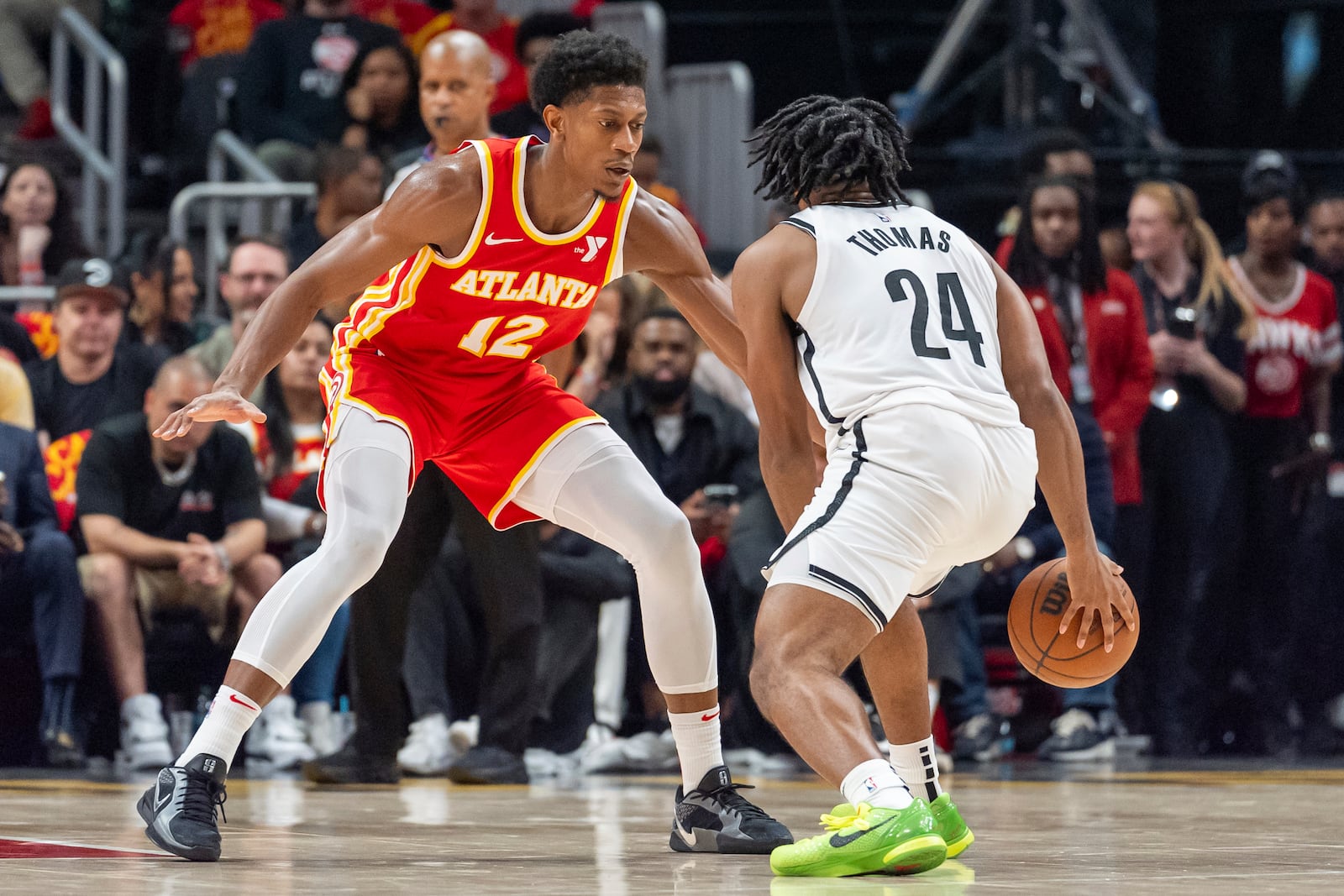 Atlanta Hawks forward De'Andre Hunter (12) guards Brooklyn Nets guard Cam Thomas (24) during the first half of an NBA basketball game, Wednesday, Oct. 23, 2024, in Atlanta. (AP Photo/Jason Allen)