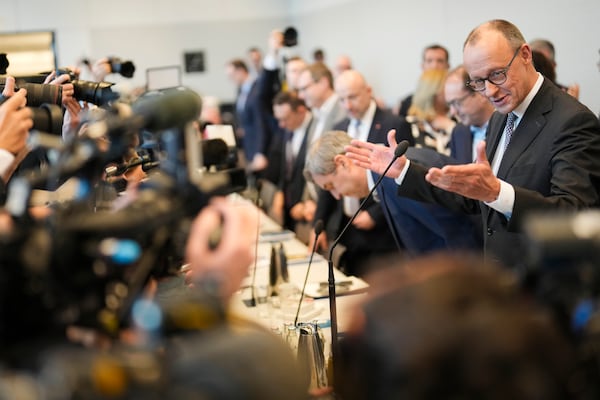 Friedrich Merz, right, leader of the Christian Democratic Union, CDU, arrives for to a faction meeting of the Christian Union party's lawmaker at the parliament Bundestag in Berlin, Germany, Tuesday, Feb. 25, 2025. (AP Photo/Markus Schreiber)