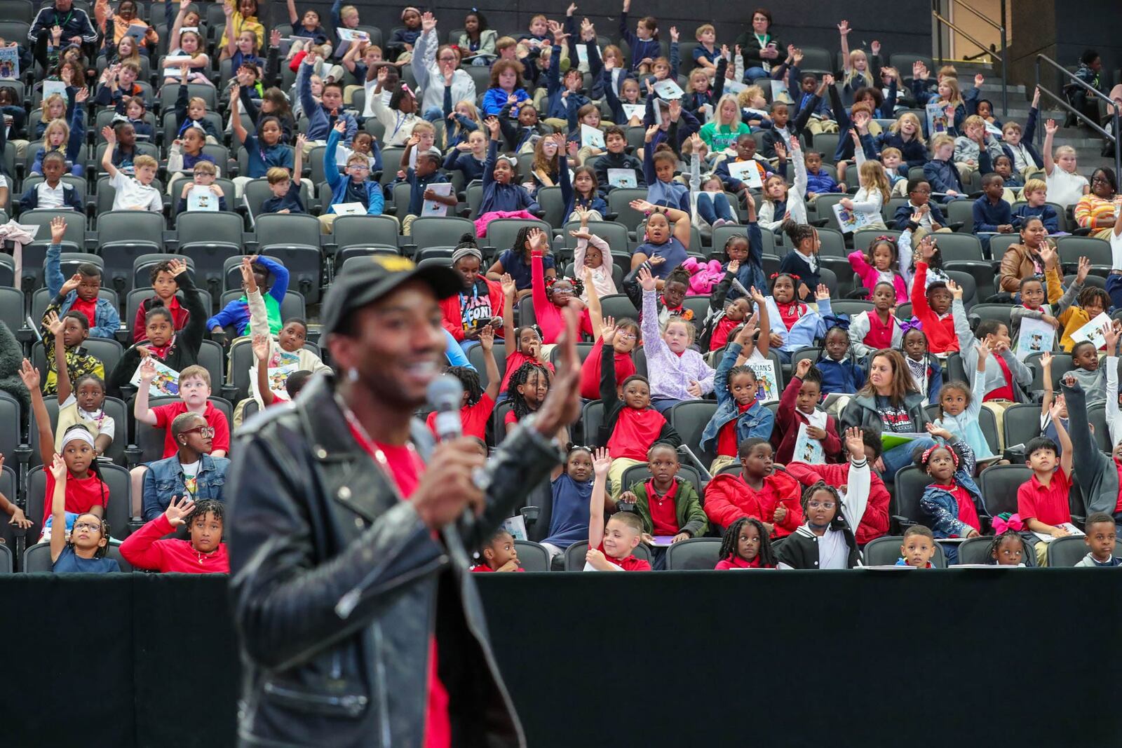 Savannah Chatham County Public Schools 2nd graders hold up their hands as Former University of Georgia and New England Patriots wide receiver Malcolm Mitchell speaks on Tuesday, October 17, 2023 during a Reading Rally at Enmarket Arena.