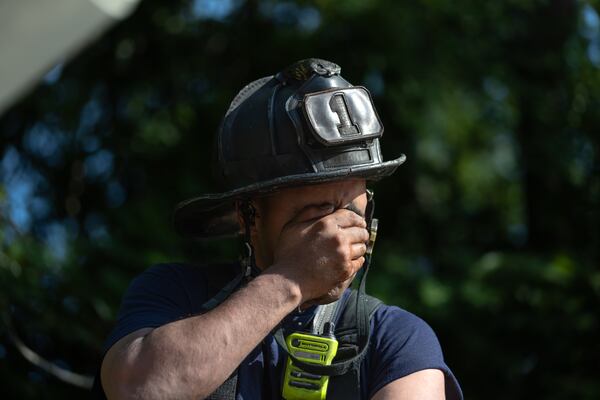 Atlanta firefighter Darryl Sharma cools down after operating the aerial ladder of Truck One in the heat. Atlanta firefighters went to it Thursday morning, June 13, 2024, battling a blaze at Morris Brown College for the second time in the past 16 months at the historic building formerly known as Gaines Hall. Crews arrived just before 8 a.m. just off Northside Drive at Martin Luther King Jr. Drive, according to Atlanta Fire Rescue. (John Spink/AJC)