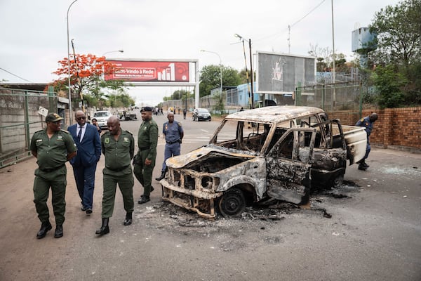 Border officials inspect a burnt-out Mozambican border patrol vehicle at the border crossing in Lebombo, South Africa, Thursday, Nov. 7, 2024. South Africa closed its border with Mozambique shortly after opening it on Thursday as post-election violence in the neighboring country escalated. (AP Photo)