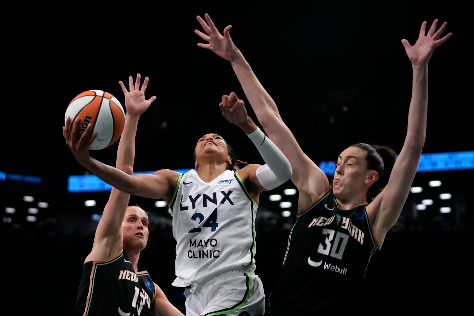 Minnesota Lynx's Napheesa Collier, center, attempts to score against New York Liberty's Leonie Fiebich, left, and Breanna Stewart, right during the second half in Game 1 of a WNBA basketball final playoff series, Thursday, Oct. 10, 2024, in New York. (AP Photo/Pamela Smith)