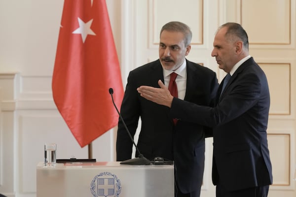 Greek Foreign Minister George Gerapetritis, right shows the way to his Turkish counterpart Hakan Fidan after the end of their news conference, in Athens, Greece, Friday, Nov. 8, 2024. (AP Photo/Thanassis Stavrakis)