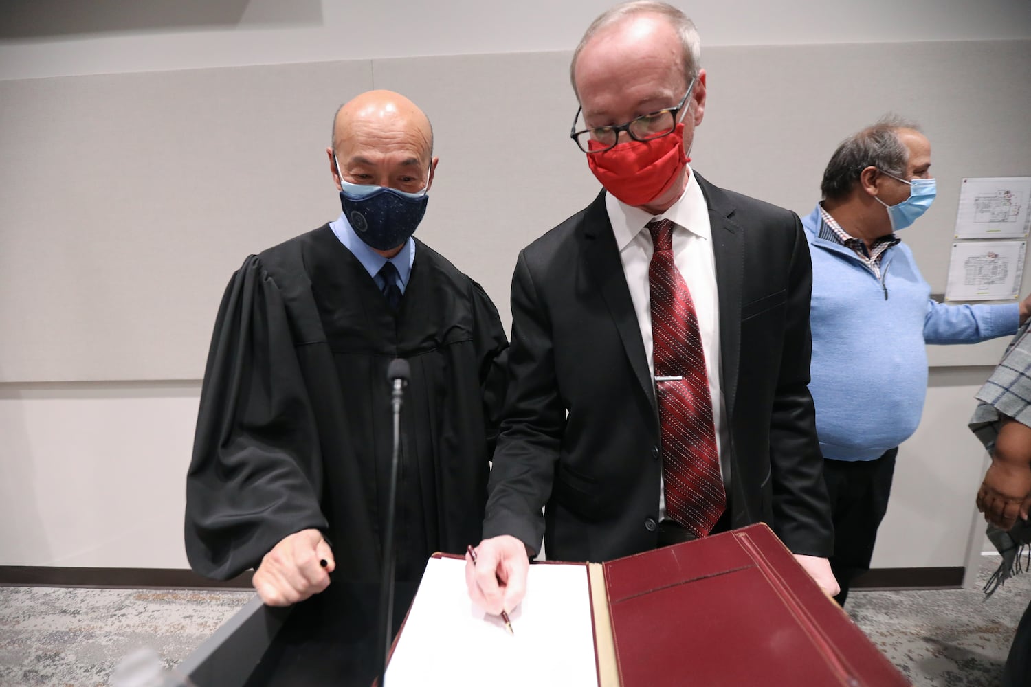 Dekalb County State Court Judge Alvin T. Wong watches the mayor of the City of Chamblee, Brian Mock, sign the official document that accredits him as the city's new mayor on Thursday, January 13, 2022. Miguel Martinez for The Atlanta Journal-Constitution