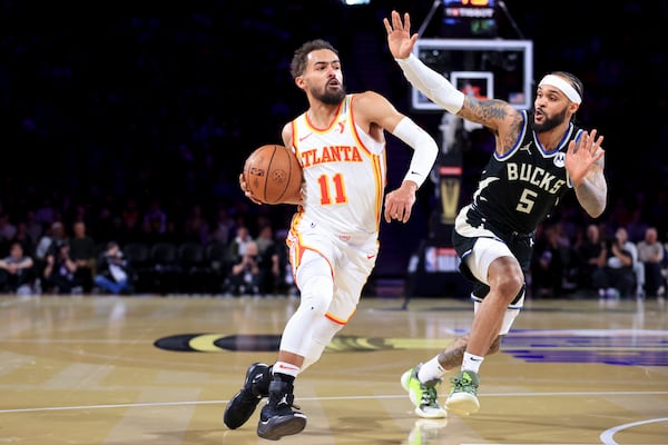 Atlanta Hawks guard Trae Young (11) drives past Milwaukee Bucks guard Gary Trent Jr. (5) during the first half of a semifinal game in the NBA Cup basketball tournament Saturday, Dec. 14, 2024, in Las Vegas. (AP Photo/Ian Maule)