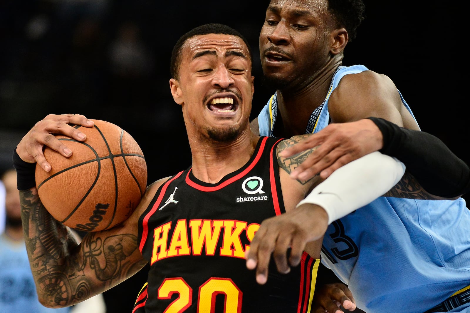 Atlanta Hawks forward John Collins (20) handles the ball against Memphis Grizzlies forward Jaren Jackson Jr. (13) in the first half of an NBA basketball game Friday, Nov. 26, 2021, in Memphis, Tenn. (AP Photo/Brandon Dill)