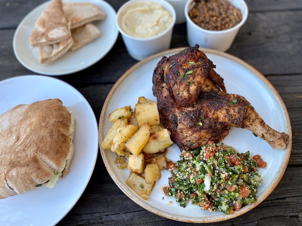 Takeout from Aviva by Kameel in Midtown: Rosemary chicken with roasted potatoes and tabouleh. Left, a pita pocket with falafel and all the fixings (hummus, baba ghanoush, cabbage salad, Nazareth salad). In the back: Pita, baba ghanoush and mujadarra.
Wendell Brock for The Atlanta Journal-Constitution