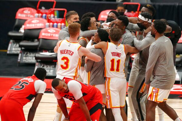 Atlanta Hawks celebrate a basket by Tony Snell at the buzzer, as Toronto Raptors' Chris Boucher (25) and Norman Powell react in an NBA basketball game Thursday, March 11, 2021, in Tampa, Fla. The Hawks won 121-120. (AP Photo/Mike Carlson)