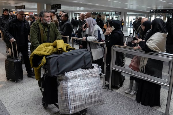 Travelers push their luggage as they arrive at the Rafik Hariri International Airport, in Beirut, Lebanon, Friday, Feb. 21, 2025. (AP Photo/Bilal Hussein)