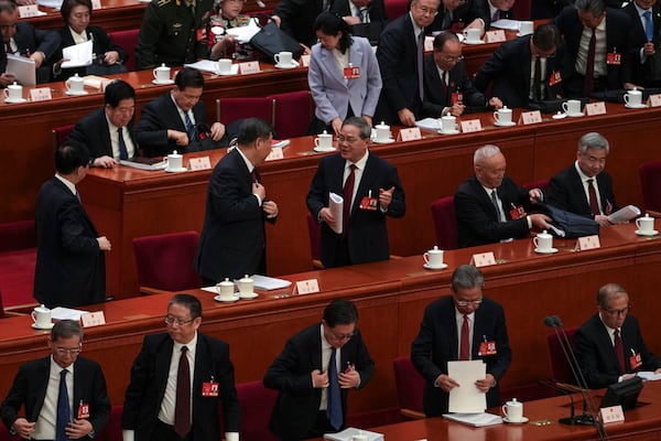 Chinese President Xi Jinping, center left, chats with his Premier Li Qiang as leaders and delegates prepare to leave after attending the opening session of the National People's Congress held at the Great Hall of the People in Beijing, Wednesday, March 5, 2025. (AP Photo/Andy Wong)