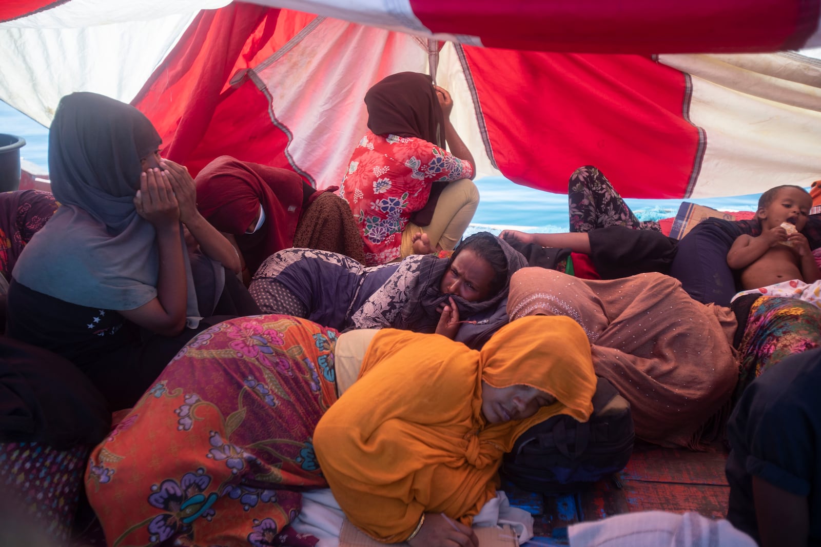 Rohingya refugees rest in their boat anchored in the waters near the coast of Labuhan Haji, Aceh province, Indonesia, Tuesday, Oct. 22, 2024. (AP Photo/Binsar Bakkara)