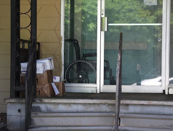 A wheelchair sits inside a door at Meadowbrook Health & Rehab in Tucker in April, beset by a COVID-19 outbreak. As of Thursday, 73 residents of the nursing home have tested positive and there have been 10 resident deaths. Nineteen staff members also have been infected. Curtis Compton ccompton@ajc.com