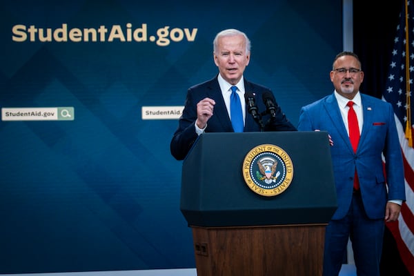 President Joe Biden speaks about the student debt relief portal beta test as Education Secretary Miguel Cardona listens in the South Court Auditorium on the White House complex in Washington, D.C, on Oct. 17, 2022. (Pete Marovich / The New York Times)