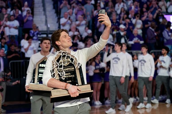 High Point players Trae Benham, front, takes video as he leads the team onto the court for a watch party for the NCAA college basketball tournament in High Point, N.C., Sunday, March 16, 2025. (AP Photo/Chuck Burton)