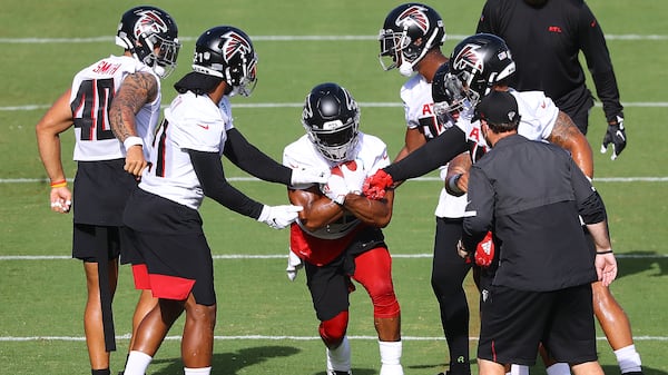 Running the gauntlet: Ito Smith works during a ballhandling drill while Keith Smith (from left), Todd Gurley, Brian Hill, Delrick Abrams and Mikey Daniel defend during training camp practice in Flowery Branch. (Curtis Compton/ccompton@ajc.com)