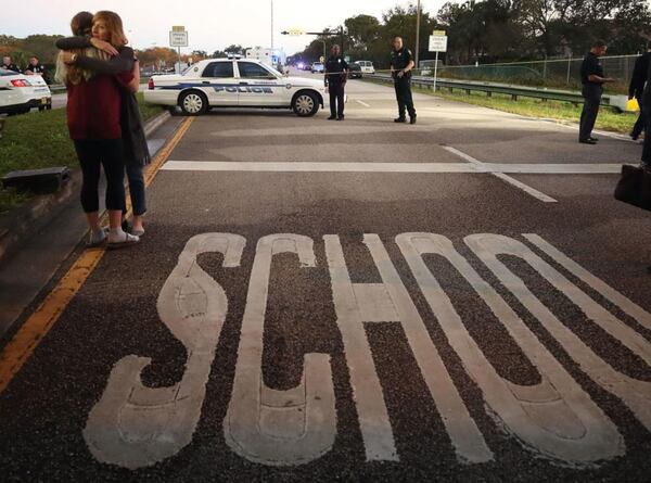 PARKLAND, FL - Kristi Gilroy (R), hugs a young woman at a police check point near the Marjory Stoneman Douglas High School where 17 people were killed by a gunman on February 14, 2018 in Parkland, Florida. Police arrested the suspect after a short manhunt, and have identified him as 19-year-old former student Nikolas Cruz.  (Photo by Mark Wilson/Getty Images)