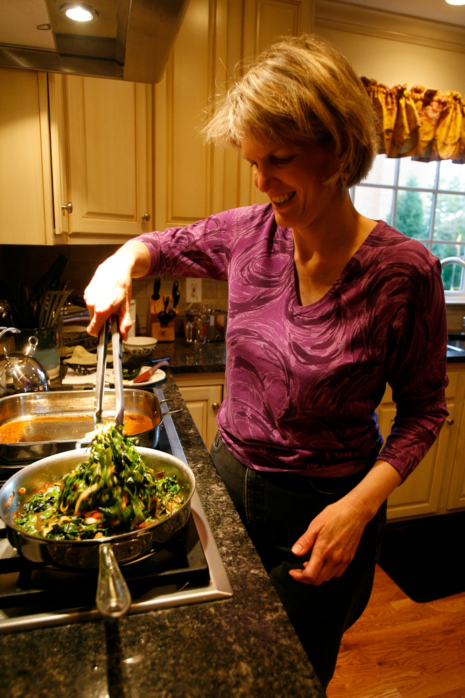 Elizabeth Lee sautes collards in a skillet with bacon, onion, garlic and hot pepper.