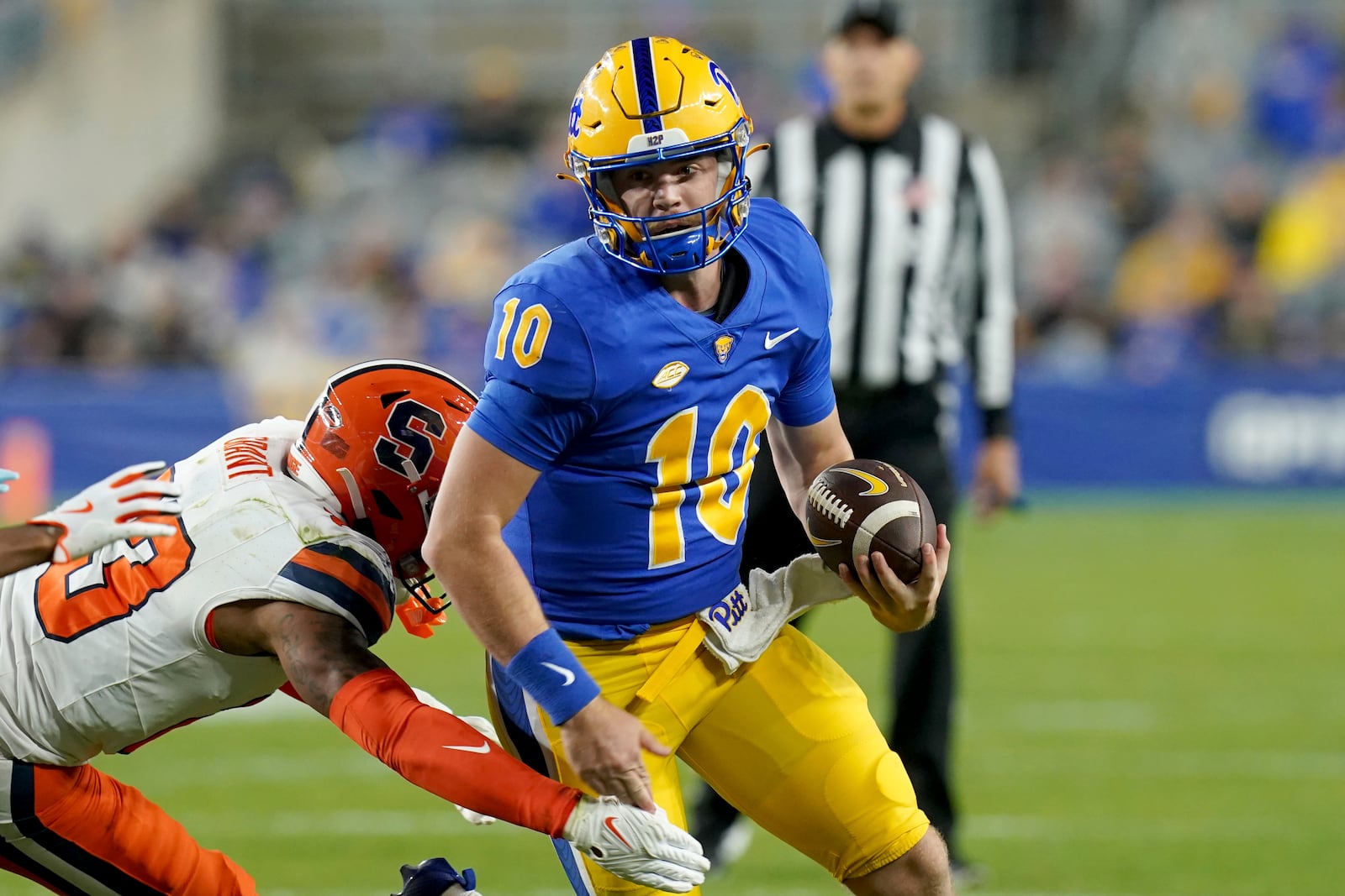 Pittsburgh quarterback Eli Holstein (10) carries as he's defended by Syracuse defensive back Devin Grant (23) during the first half of an NCAA college football game, Thursday, Oct. 24, 2024, in Pittsburgh. (AP Photo/Matt Freed)