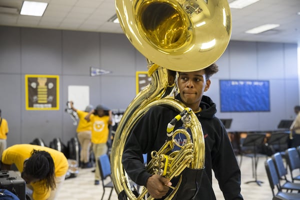 Douglass High School marching band Tuba section leader Stephon Wheeler gathers his instrument before after-school practice begins . ALYSSA POINTER/ALYSSA.POINTER@AJC.COM