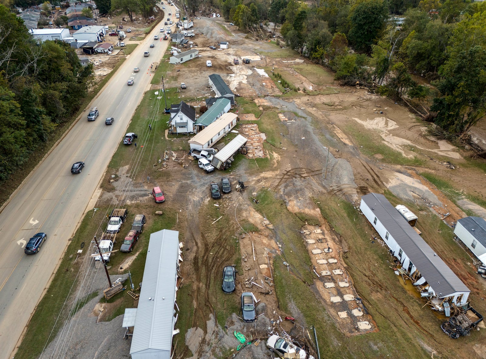 FILE - Homes and vehicles that were damaged in a flood from Hurricane Helene sit on the side of a road near the Swannanoa River, Oct. 1, 2024, in Swannanoa, N.C. (AP Photo/Mike Stewart, File)