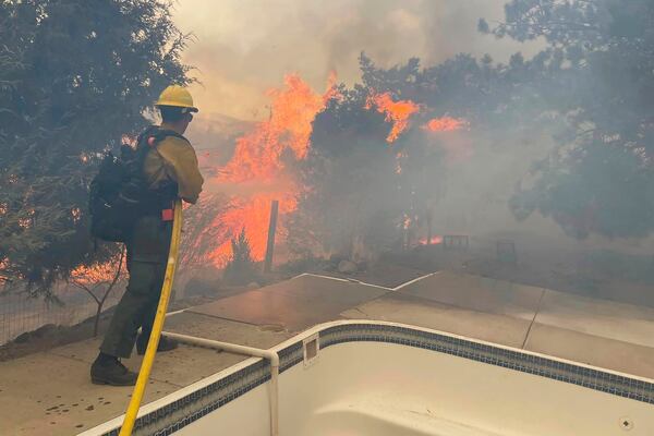 In this handout photo provided by the Reno Fire Department, fire crews battle the Callahan Fire, which caused the evacuations of hundreds of homes southwest of Reno, Nev., Monday, Nov. 11, 2024. (Reno Fire Department via AP)