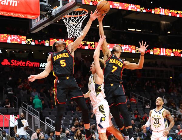 Hawks forward Kevin Knox II (left) and guard Timothe Luwawu-Cabarrot block a shot during the fourth quarter of a 133-112 victory Tuesday night in Atlanta. (Curtis Compton / Curtis.Compton@ajc.com)