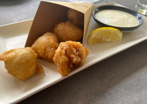 At Casa Robles, an order of pescaito frito (crispy fried cod balls), is presented in a paper cone, just like at a fried fish shop (freiduría) in Seville, Spain. Ligaya Figueras/ligaya.figueras@ajc.com