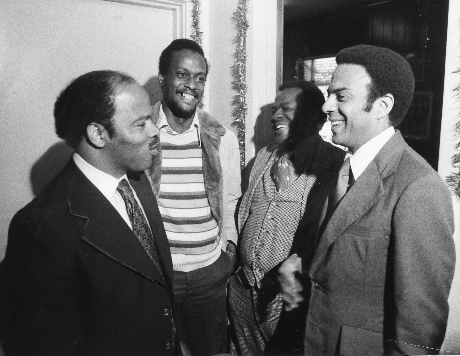 John Lewis laughs with Andrew Young and two others on Dec. 23, 1976. Lewis worked on Young's congressional campaigns in the 1970s before Young vacated the seat in 1977. In the 1980s, with Young as Atlanta mayor and Lewis on the City Council, the two saw their friendship tested on a number of issues. (Jerome McClendon / AJC Archive at GSU Library Jerome McClendon)