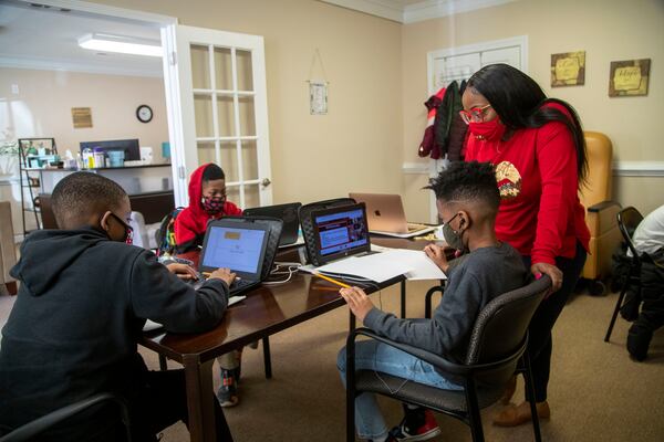 02/08/2021 —Stockbridge, Georgia — Kaylie Ramsey, owner of Kay’s Research Center, assists fourth grader Zacharie Savage with an assignment as he participates in virtual-learning at Kay’s Research Center in Stockbridge, Monday, February 8, 2021. The center hosts more than 10 students from Clayton, DeKalb and Henry counties as they continue to participate in virtual learning. (Alyssa Pointer / Alyssa.Pointer@ajc.com)