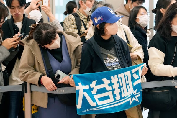 Fans of Los Angeles Dodgers's Shohei Ohtani wait for the team arrival at Tokyo International Airport Thursday, March 13, 2025, in Tokyo, as Dodgers is scheduled to play their MLB opening games against Chicago Cubs in Tokyo on March 18-19. (AP Photo/Hiro Komae)